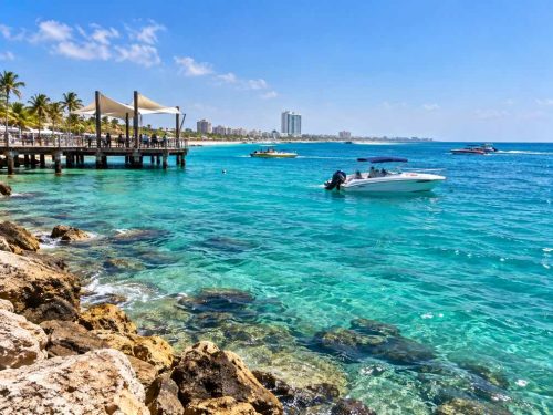 آب و هوای آفتابی کیش با ساحل، نخل‌ها و آسمان صاف