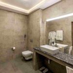 حمام اختصاصی هتل آرارات ایروان با روشویی، آینه و سرویس بهداشتی