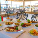 رستوران هتل کریستال سنترو ریزورت با میز غذا و نمای دریا