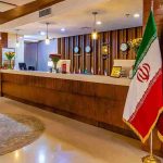 میز پذیرش هتل سی نور مشهد با فضای مدرن و پرچم مجموعه