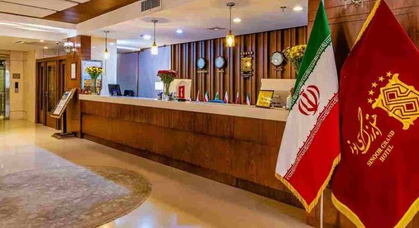 میز پذیرش هتل سی نور مشهد با فضای مدرن و پرچم مجموعه