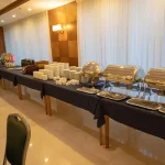 بوفه رستوران هتل رضوان مشهد با ظروف گرم غذا و میز پذیرایی