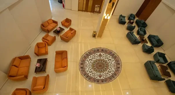 لابی هتل رضوان مشهد با مبلمان نارنجی و سبز و فرش ایرانی
